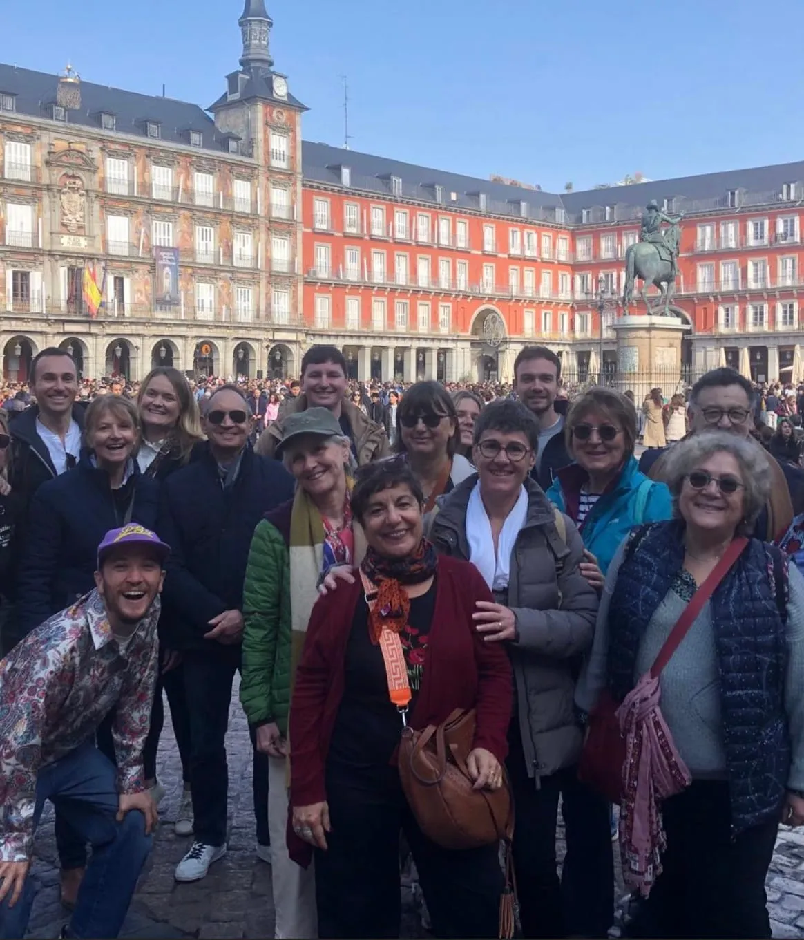 Lucas et son groupe de visiteurs francophones posant devant la Plaza Mayor de Madrid, statue de Philippe IV en arrière-plan